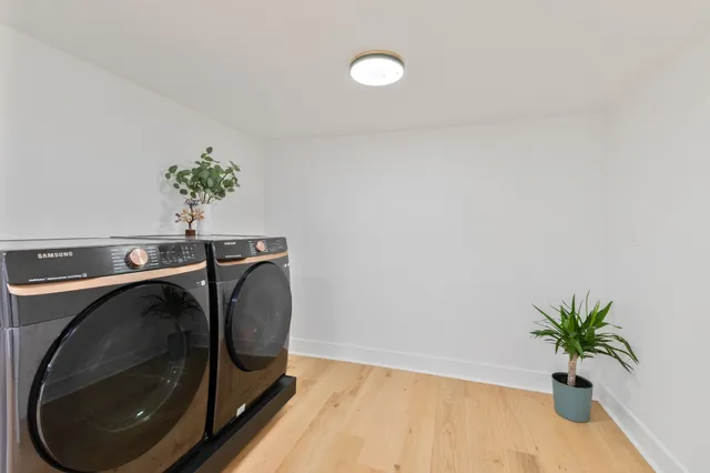 a utility room with wooden floor washer and dryer
