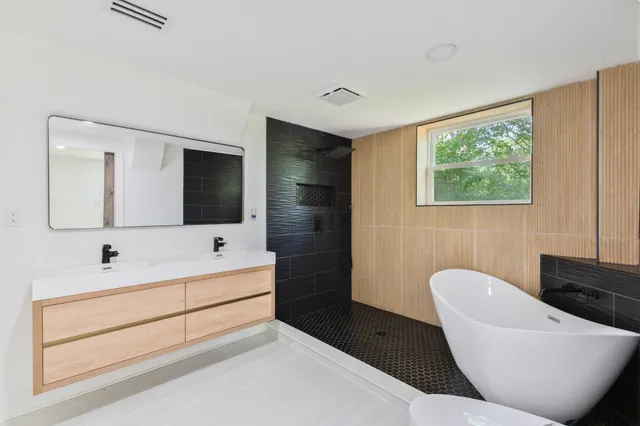 a bathroom with a bathtub sink and mirror