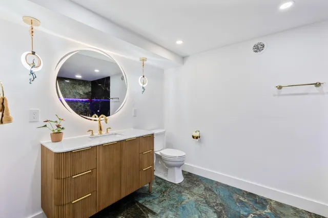 a bathroom with a toilet sink and mirror