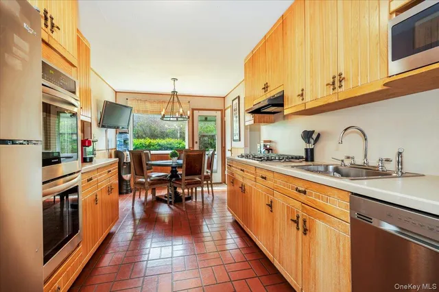 a kitchen with stainless steel appliances granite countertop a stove a sink dishwasher and cabinets with wooden floor