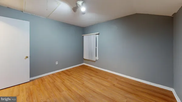 a view of empty room with wooden floor and furniture