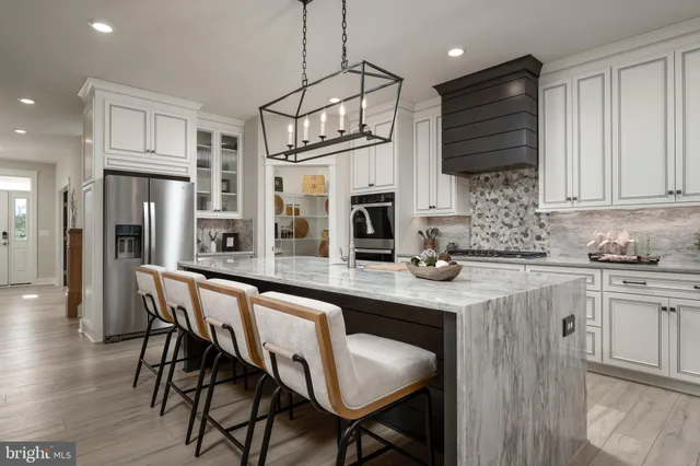 a kitchen with stainless steel appliances granite countertop a kitchen island a stove a table and chairs in it