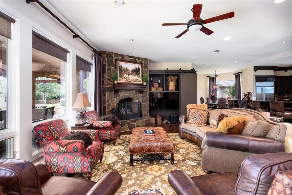 2312 Cactus Rio Lane Weatherford, TX 76087 - Photo 11 of 37 a living room with furniture a large window and a fireplace
