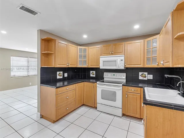 a kitchen with granite countertop cabinets stainless steel appliances and a sink