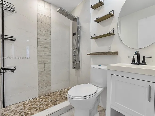 a bathroom with a sink a toilet and shower