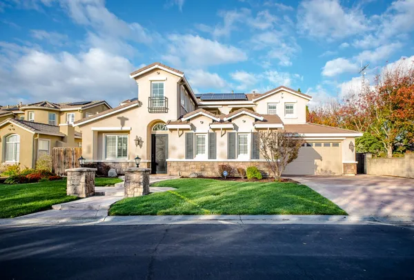 a front view of a house with a yard and garage