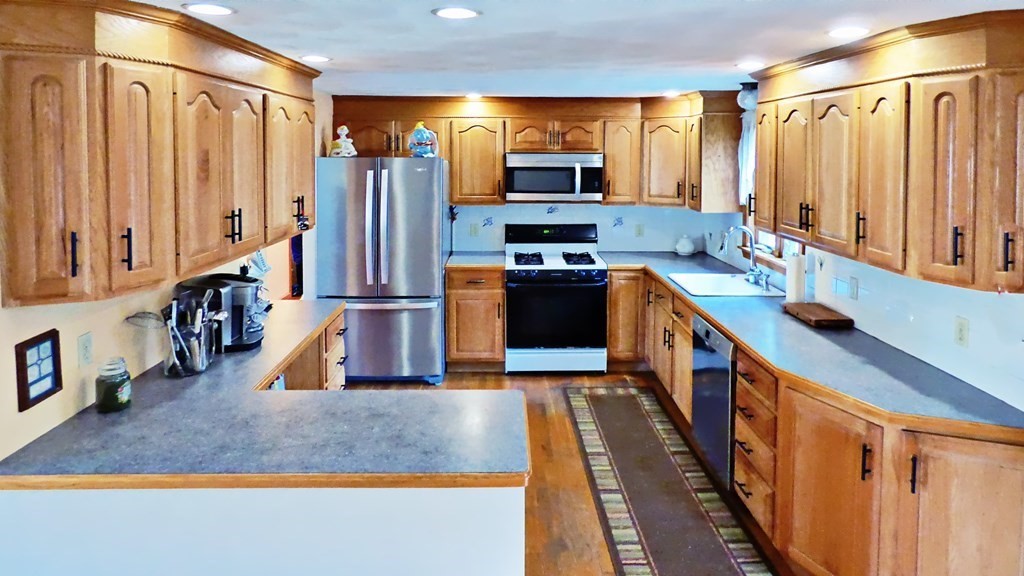115 Richard Drive Hanover, MA 02339 - Photo 3 of 18 a kitchen with stainless steel appliances granite countertop a refrigerator a stove and a sink with wooden floor