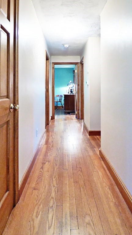 115 Richard Drive Hanover, MA 02339 - Photo 8 of 18 a view of a hallway with wooden floor and a bathroom