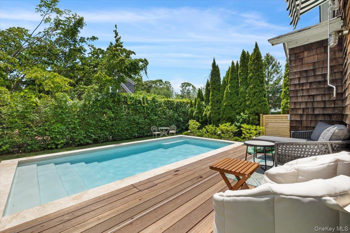 19 New Jersey Avenue Bellport, NY 11713 - Photo 15 of 17 a view of a patio with lawn chairs under an umbrella