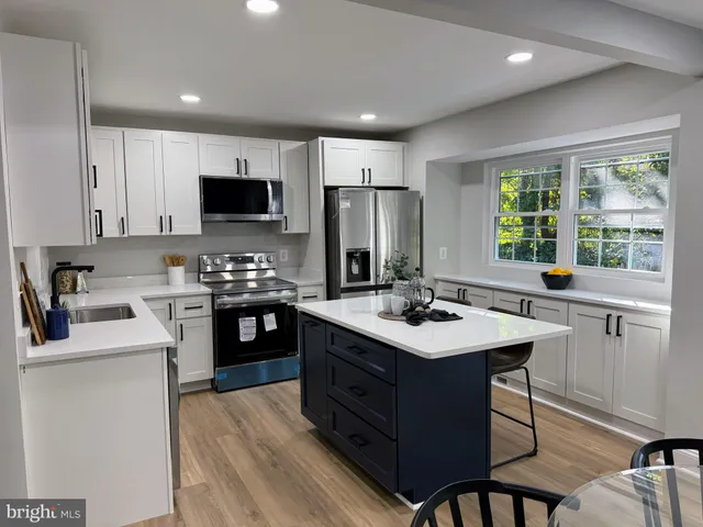 a kitchen with a sink stove top oven and refrigerator
