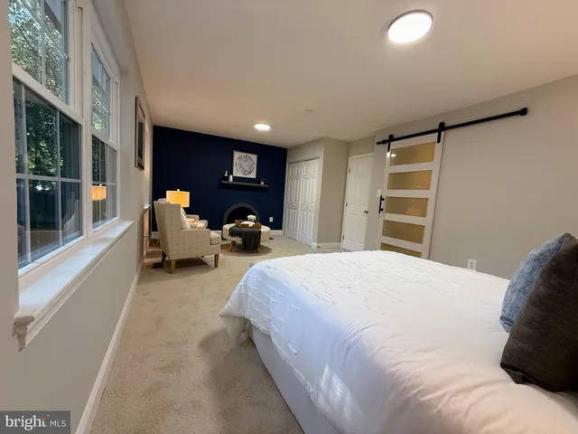 a spacious bedroom with a bed and wooden floor