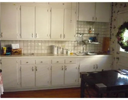 a kitchen with granite countertop white cabinets and sink