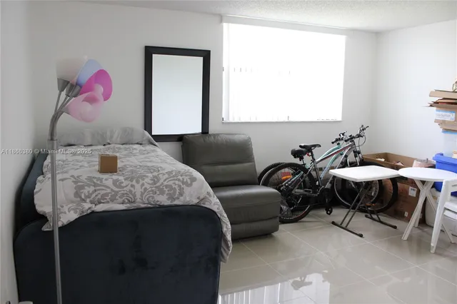 a balcony with table and chairs with potted plants
