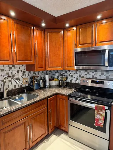 a kitchen with stainless steel appliances a refrigerator a stove a microwave and cabinets