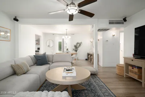 a living room with furniture a flat screen tv and a chandelier