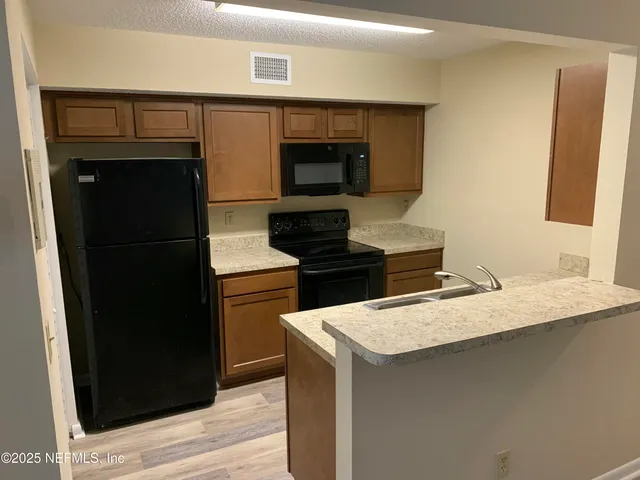 a kitchen with a refrigerator and a stove