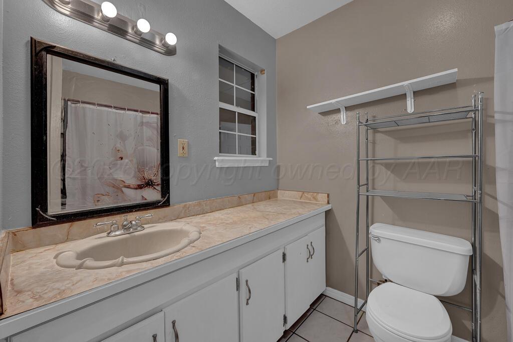 2106 South Cleveland Street Amarillo, TX 79103 - Photo 15 of 26 a bathroom with a granite countertop toilet sink and mirror