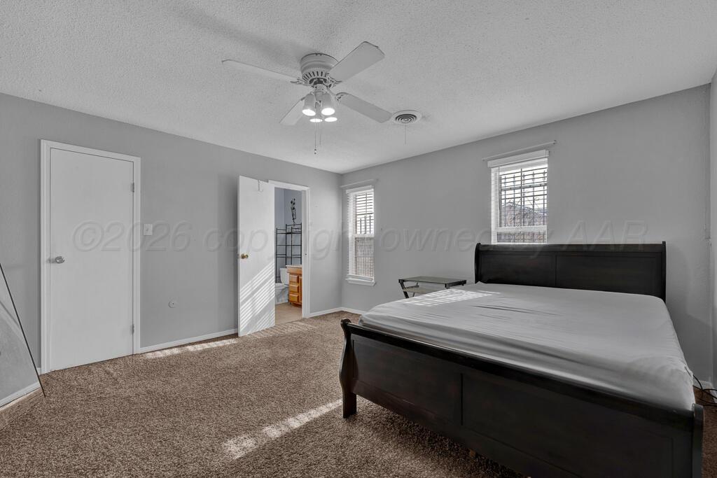 2106 South Cleveland Street Amarillo, TX 79103 - Photo 18 of 26 a bedroom with a large bed and a chandelier