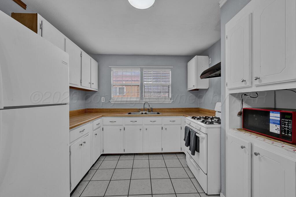 2106 South Cleveland Street Amarillo, TX 79103 - Photo 7 of 26 a kitchen with cabinets appliances a sink and a window
