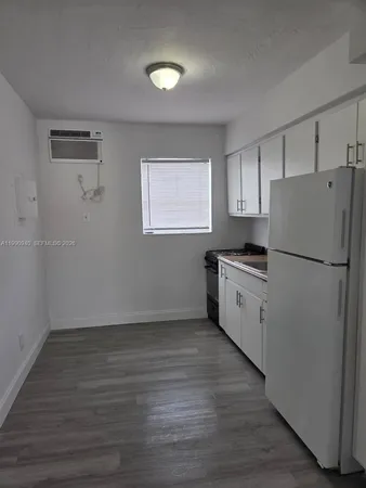 a kitchen with a refrigerator and a stove top oven