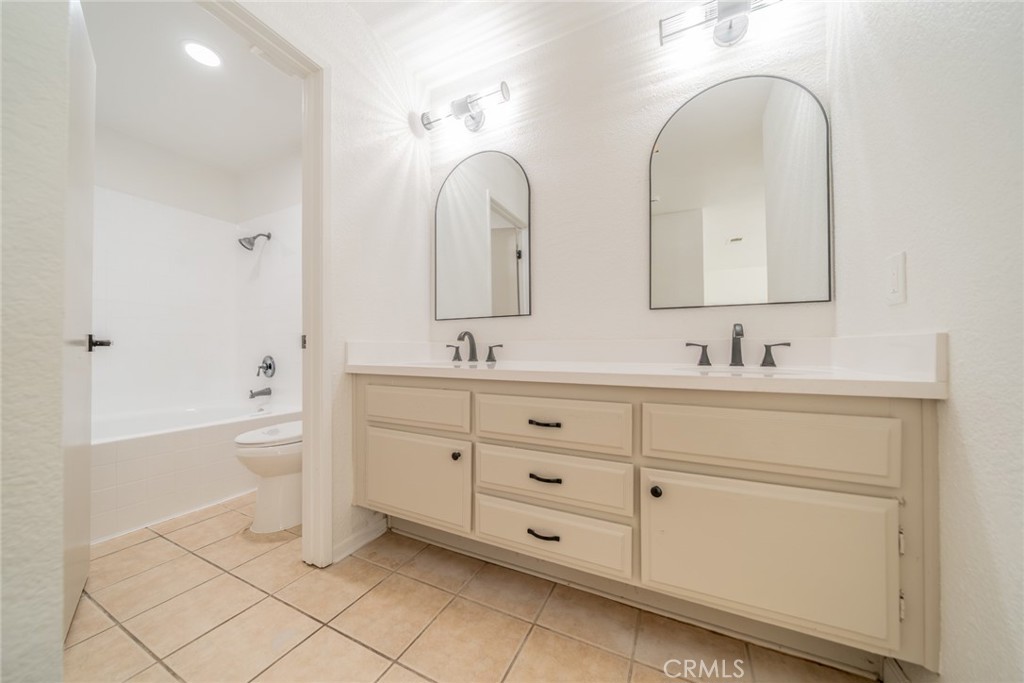 14721 Weeping Willow Lane Fontana, CA 92337 - Photo 16 of 25 a spacious bathroom with a double vanity sink a mirror and a bathtub