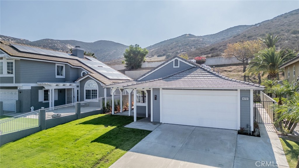 14721 Weeping Willow Lane Fontana, CA 92337 - Photo 22 of 25 a view of a white house next to a yard with potted plants