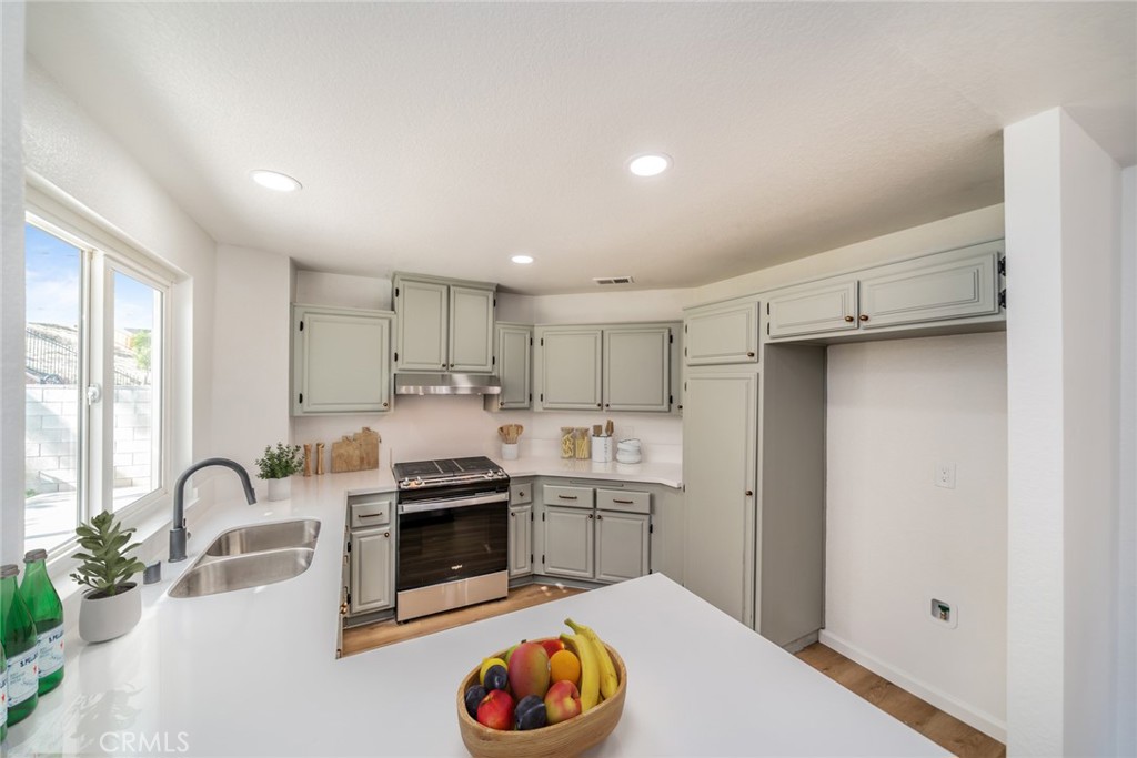 14721 Weeping Willow Lane Fontana, CA 92337 - Photo 6 of 25 a kitchen with stainless steel appliances granite countertop a stove a sink and a refrigerator