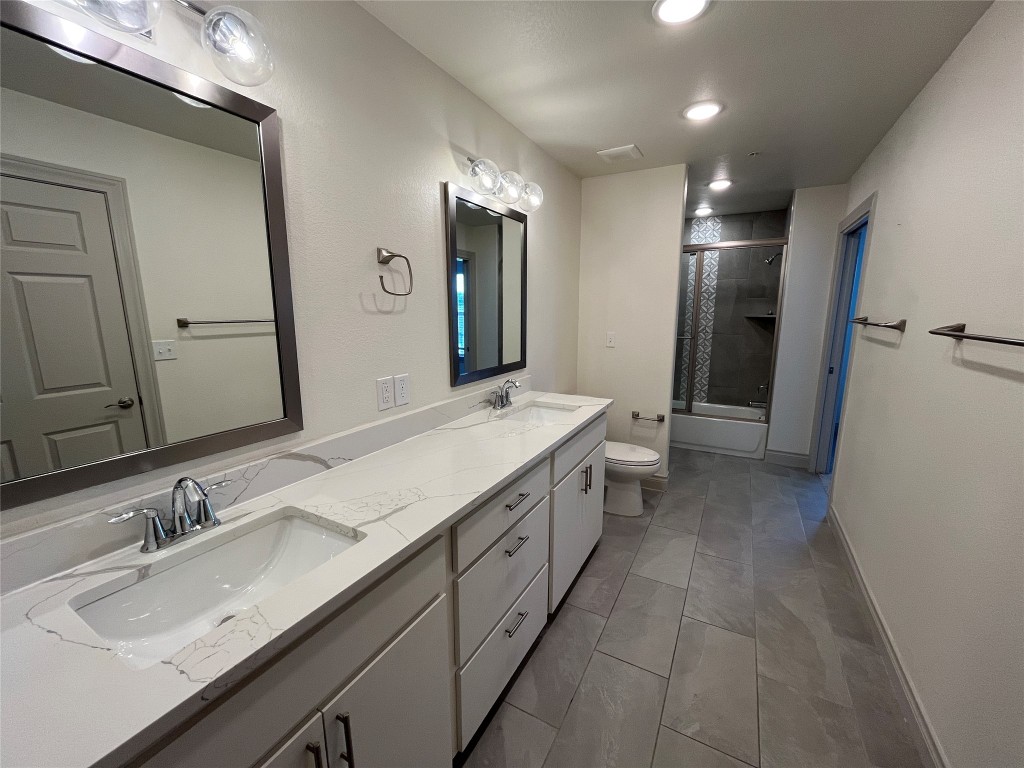 2105 Tiger Trail, Unit 502 Round Rock, TX 78664 - Photo 11 of 16 a bathroom with a double vanity sink and a mirror