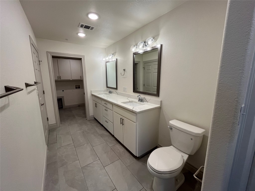 2105 Tiger Trail, Unit 502 Round Rock, TX 78664 - Photo 12 of 16 a spacious bathroom with a toilet sink and mirror
