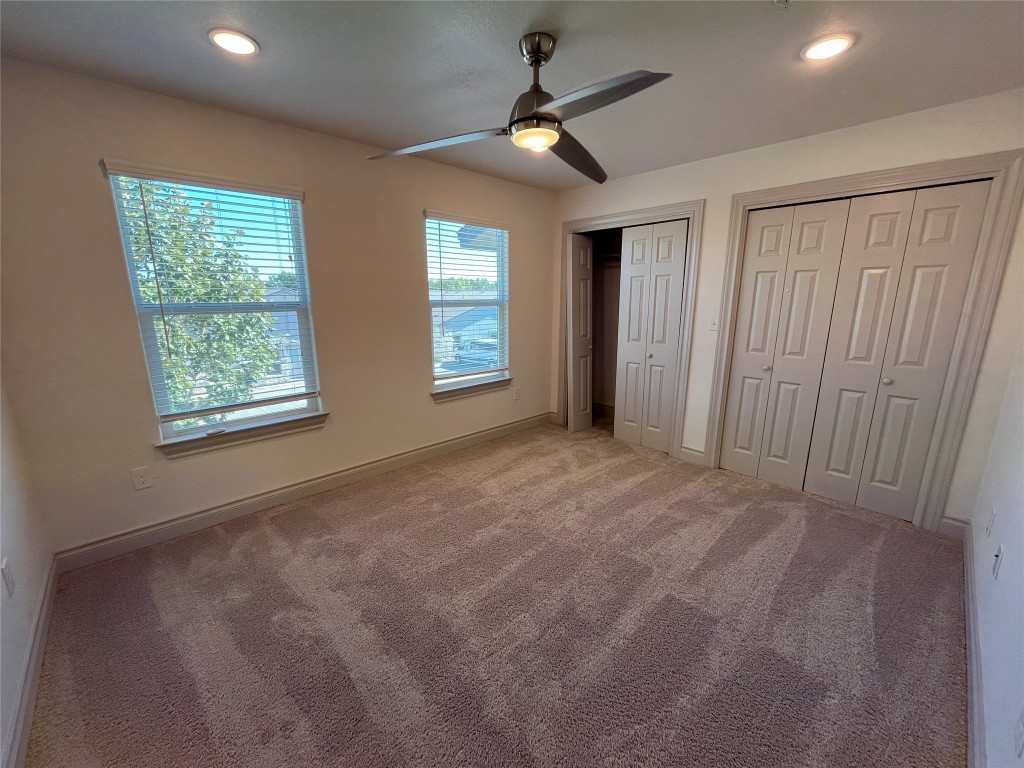 2105 Tiger Trail, Unit 502 Round Rock, TX 78664 - Photo 9 of 16 en empty room with windows and a ceiling fan
