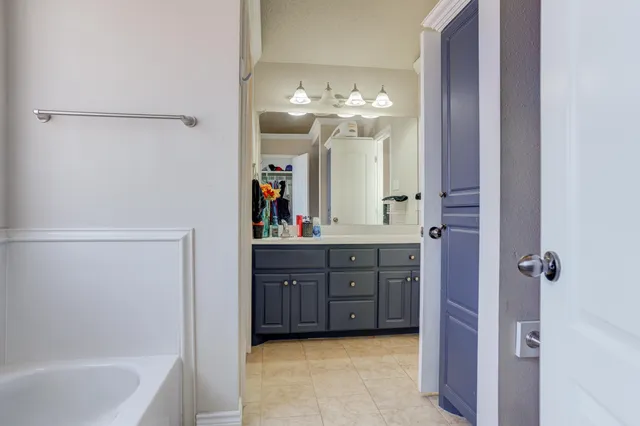 a bathroom with a bathtub sink and mirror