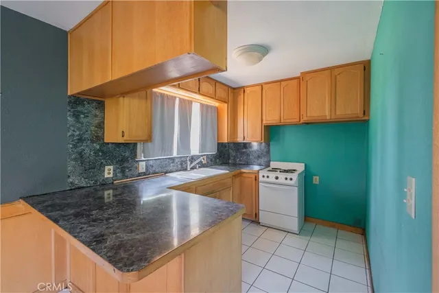 a view of a hallway to an empty room with a fireplace and a window