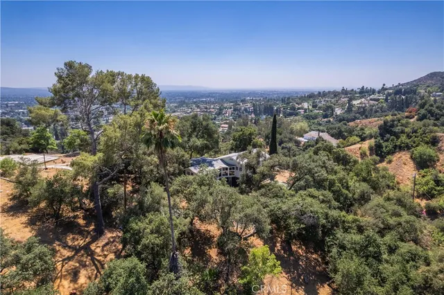 a view of a dry yard with trees