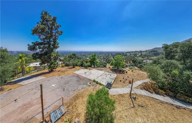 an empty room with wooden floor fireplace and windows
