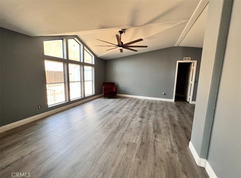 3700 Quartz Canyon Road, Unit 21 Jurupa Valley, CA 92509 - Photo 2 of 11 an empty room with wooden floor fan and windows
