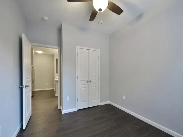 an empty room with wooden floor and cabinet