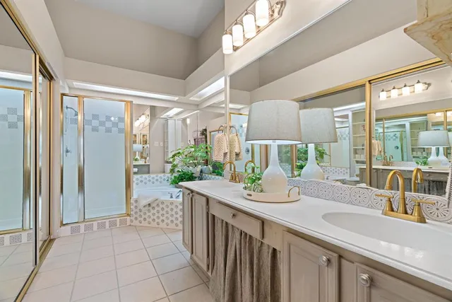 a bathroom with a granite countertop sink a mirror and shower