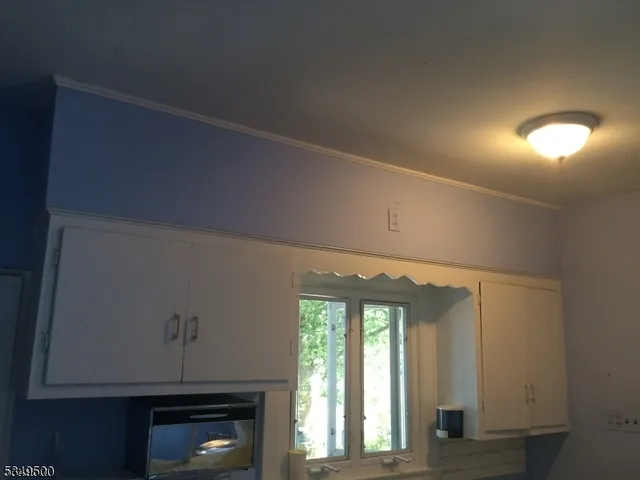 a view of an empty room with a fireplace and a window