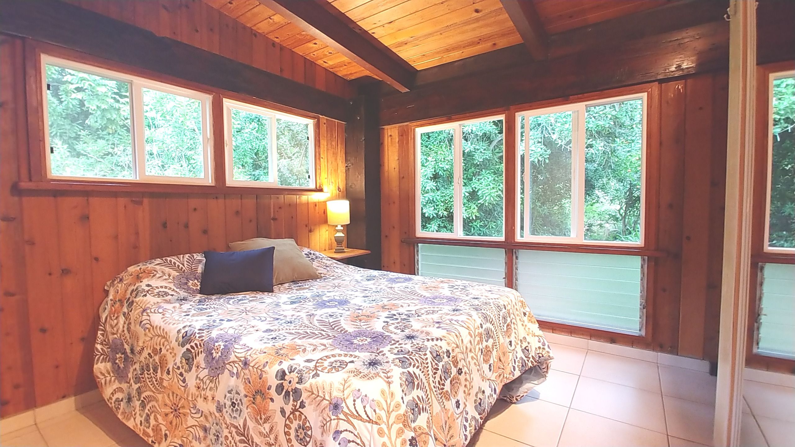 81-6315 Hawaiʻi Belt Road Captain Cook, HI 96750 - Photo 13 of 13 a bed sitting in a bedroom next to a window