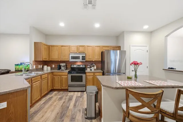 a kitchen with stainless steel appliances granite countertop a refrigerator stove and sink