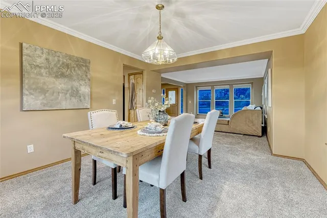 a view of a dining room with furniture and a chandelier