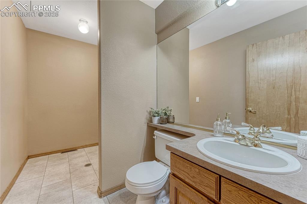 5514 Saxon Lane Colorado Springs, CO 80918 - Photo 22 of 50 a bathroom with a sink a toilet a mirror and vanity