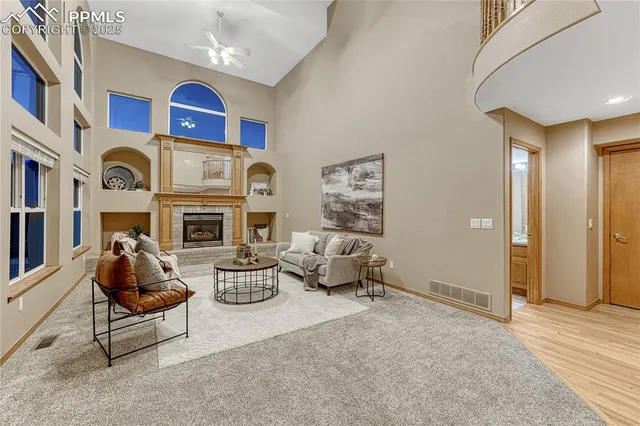 a living room with fireplace furniture and a large window
