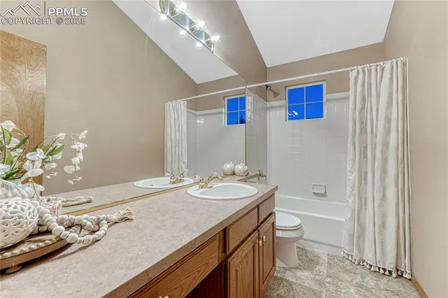 a bathroom with a granite countertop sink a toilet and shower
