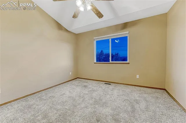 an empty room with a ceiling fan and a window