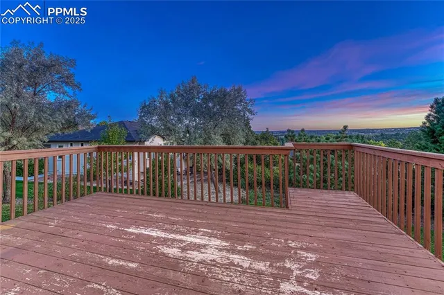 a balcony with wooden floor and city view