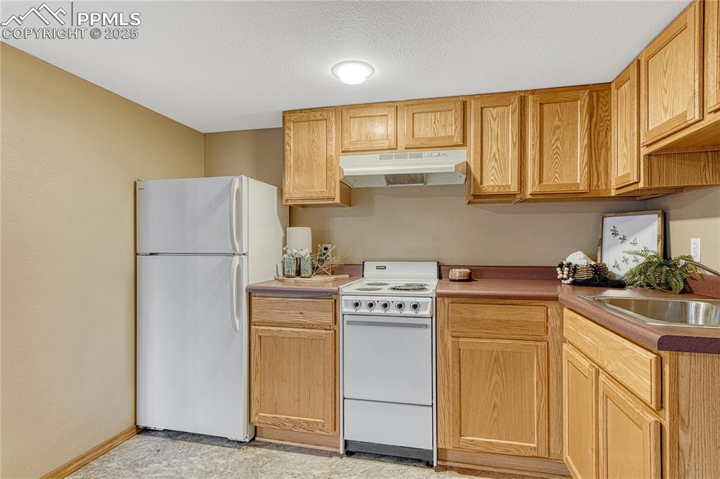 5514 Saxon Lane Colorado Springs, CO 80918 - Photo 42 of 50 a kitchen with a stove a sink and a refrigerator