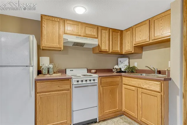 a kitchen with stainless steel appliances granite countertop a stove a sink dishwasher and a refrigerator