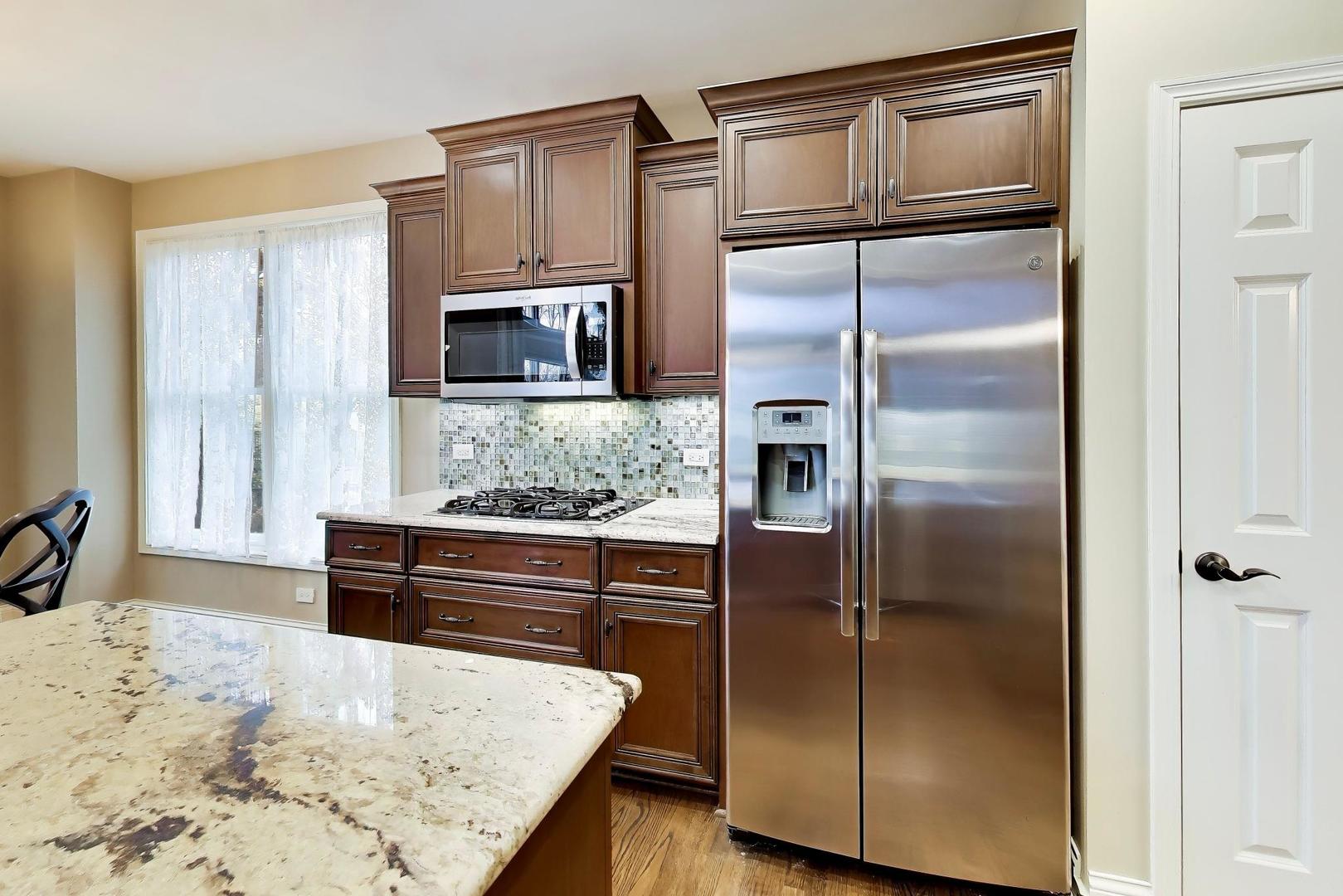 1N598 Golf View Lane Winfield, IL 60190 - Photo 11 of 33 a kitchen with granite countertop a refrigerator and a sink
