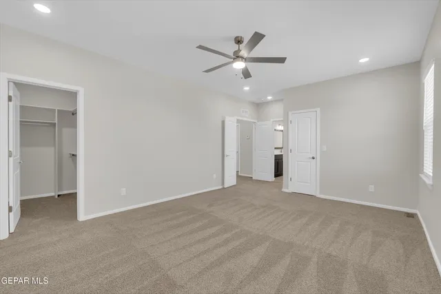 a view of an empty room with a ceiling fan